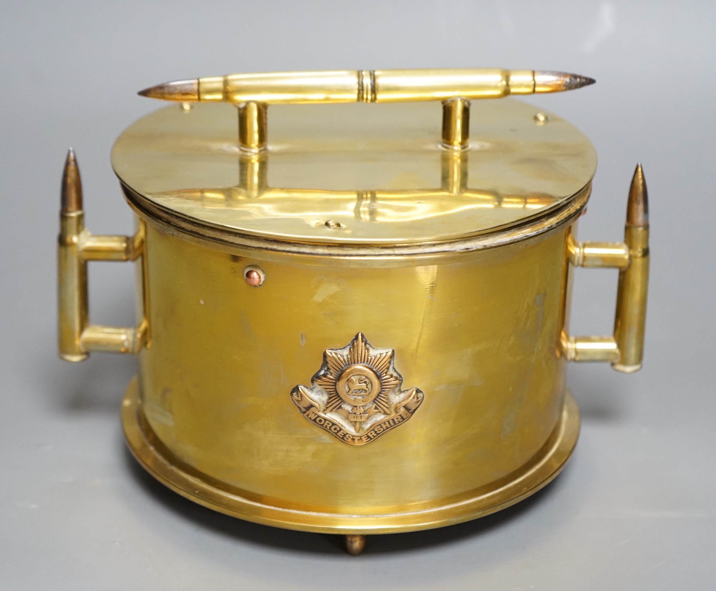 A WWI trench art biscuit barrel with applied Worcestershire regimental badge, the base dated 1918. 22cm handle to handle